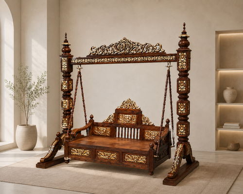 An ornate dark wood swing bed with intricate gold and beige inlay carvings, set in a bright, modern room with a beige rug and a potted plant.