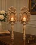Pair of ornate carved wood and MDF candle stands in an elegant classic interior