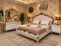 Royal Aurelia tufted luxury bed with cream upholstery and gold carved detailing in an elegant bedroom interior